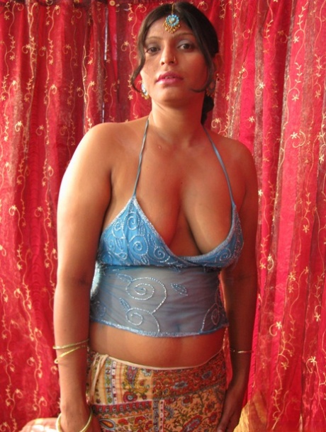 Chubby Indian woman unveils her natural tits and shaved pussy on a bed