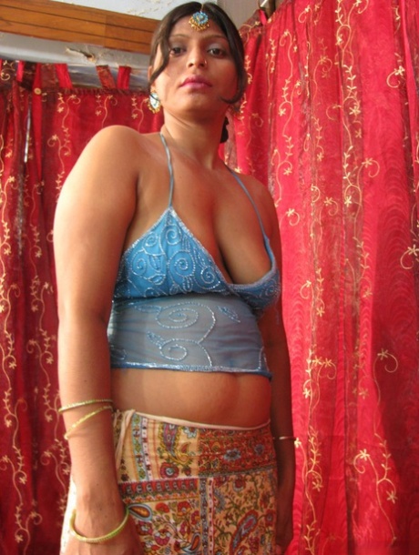 Chubby Indian woman unveils her natural tits and shaved pussy on a bed